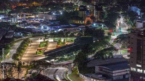 Fototapeta Naklejka Na Ścianę i Meble -  Aerial view to busy bus terminal in Singapore night timelapse.