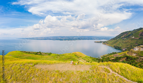 Aerial: lake Toba and Samosir Island view from above Sumatra Indonesia. Huge volcanic caldera covered by water, traditional Batak villages, green rice paddies, equatorial forest.