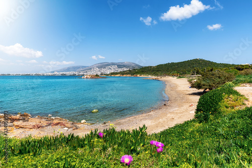 Der Strand von Kavouri an der südlichen Athen Riviera mit türkisem Wasser und Sicht auf die Stadt, Vouliagmeni, Athen