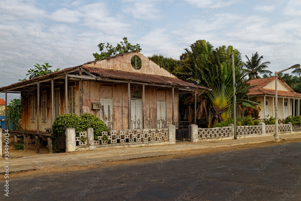 An abandoned beachfront House, with Corrugated metal facings and roof, on the Beach Road and promenade in Sao Tome