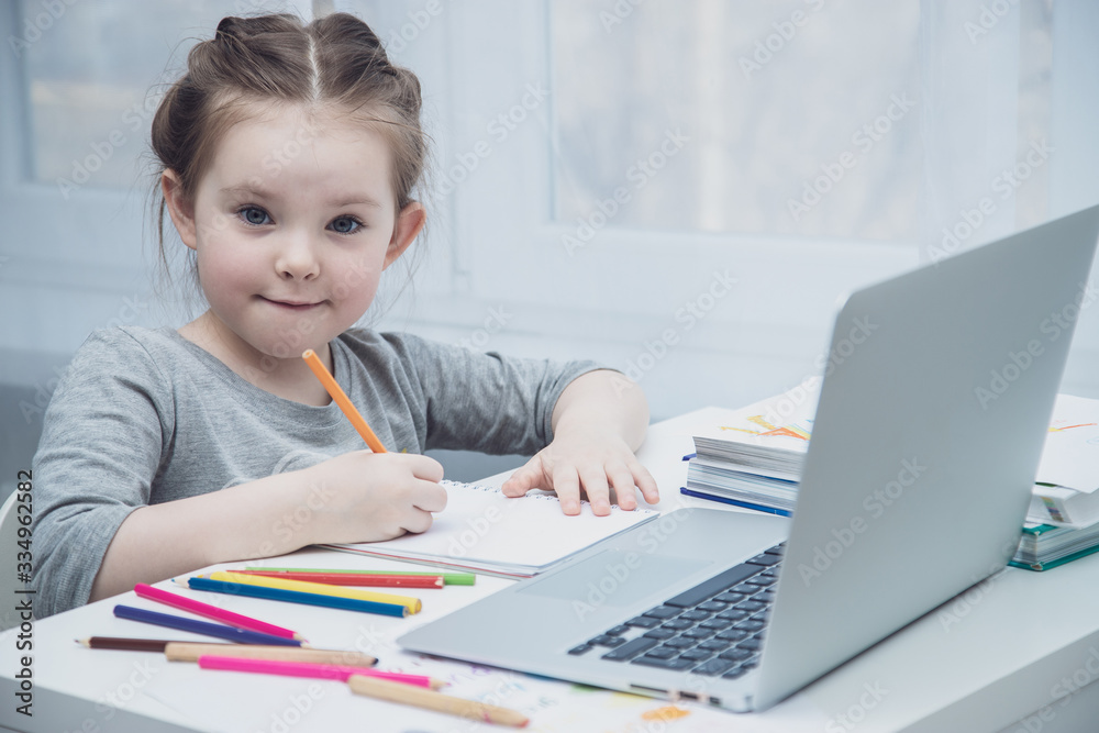 Cute little girl smiling and looking at laptop, Little girl using laptop Cute little girl smiling and looking at laptop, Little girl using laptop
