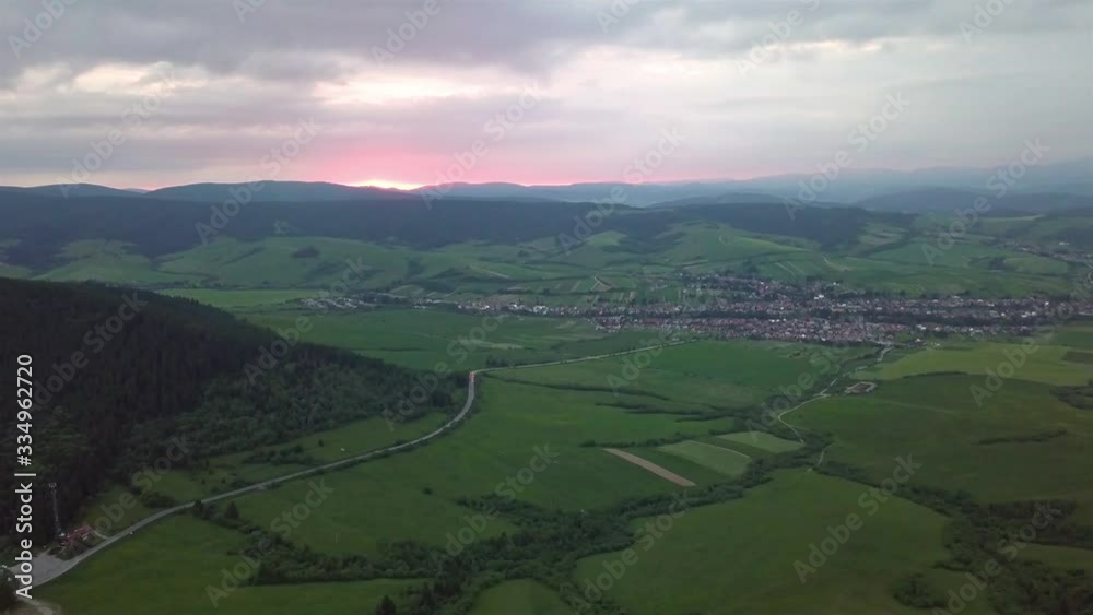 Aerial view of Tatras mountains with road and village on background on sunset Aerial view of Tatras mountains with road and village on background on sunset