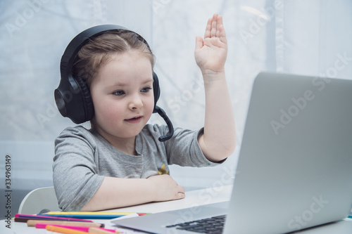 Cute little girl smiling and looking at laptop  Little girl using laptop