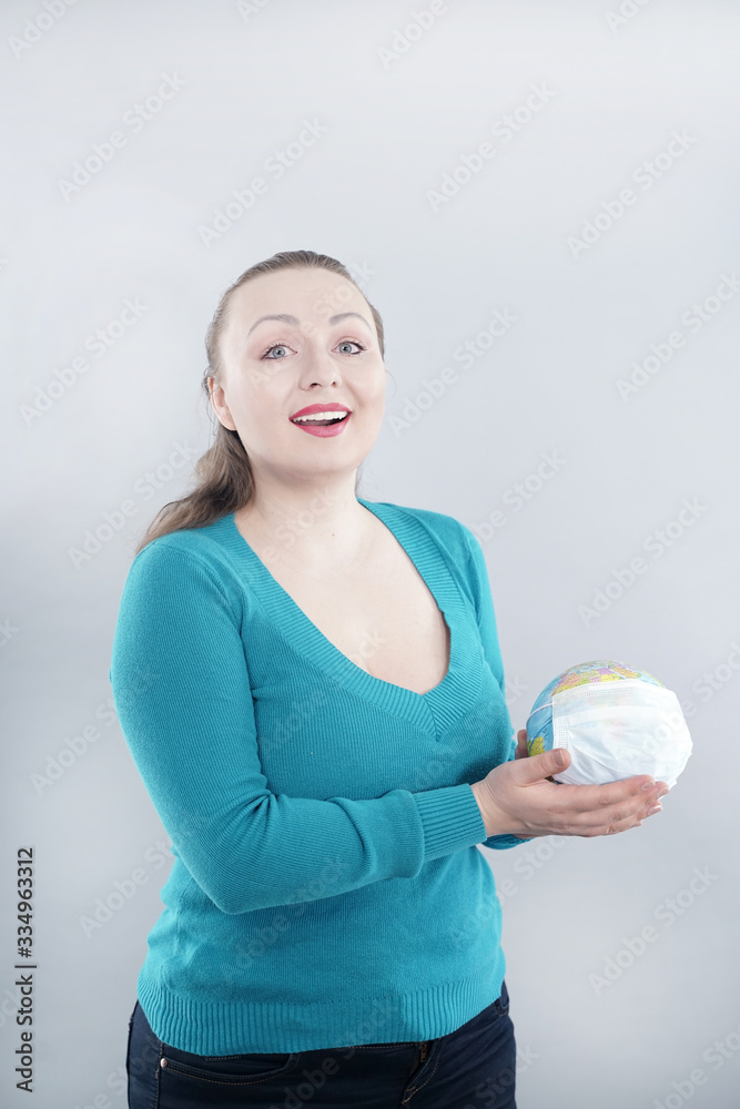 Global Flu Pandemic Concept. Woman with world globe With Medical Mask on white studio background.