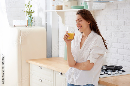 Portrait of beautiful young woman having breakfast in the kitchen.