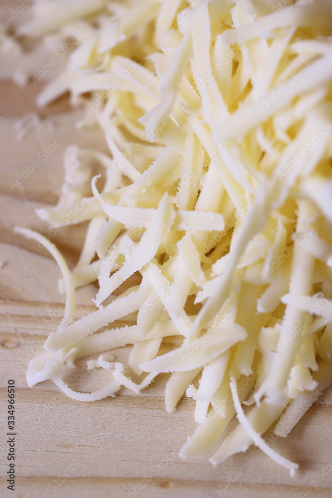 Grated cheese on wooden chopping board