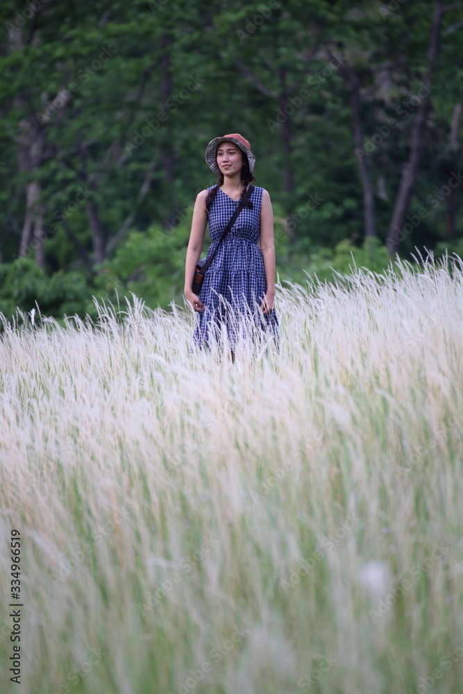 A woman standing in grass color white, Thailand A woman standing in grass color white, Thailand