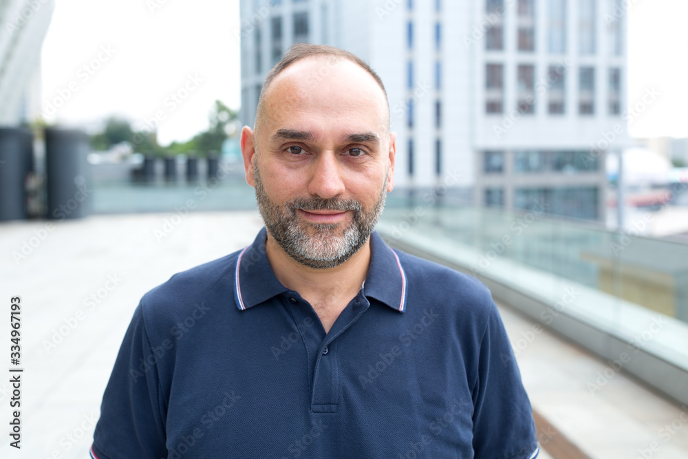 Portrait of a middle aged man on a city street background.