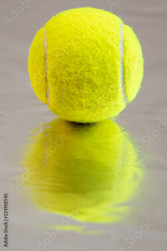 green tennis ball with deep bokeh on a silver background