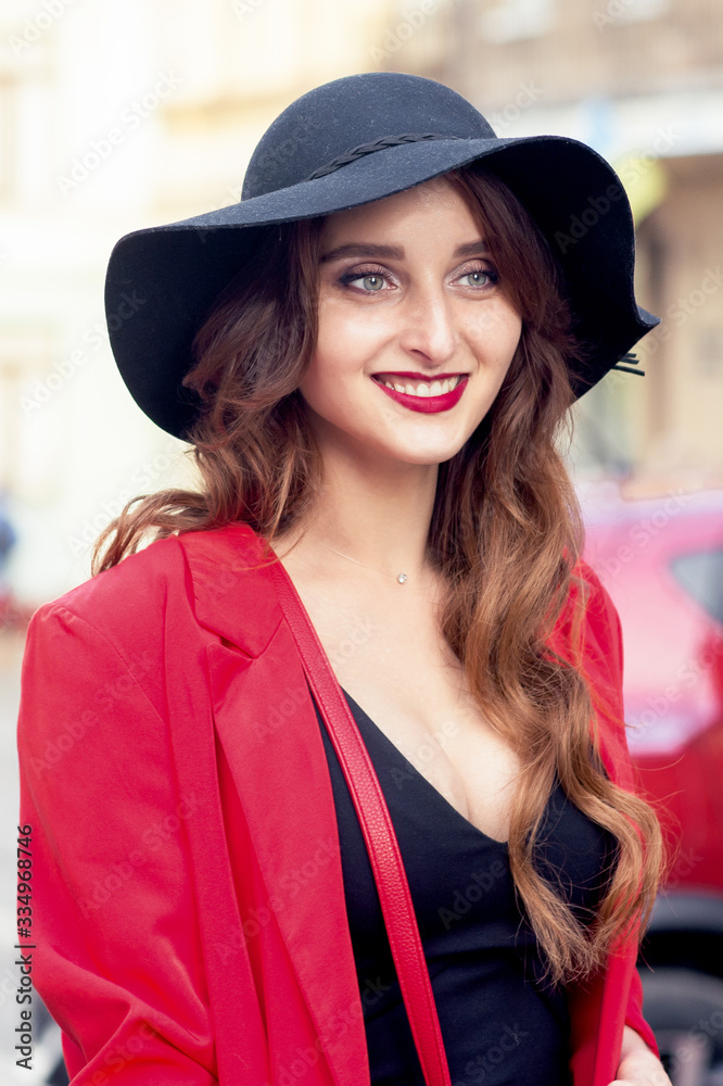 Portrait of smiling young woman in black hat looking at camera outdoors. Portrait of smiling young woman in black hat looking at camera outdoors.