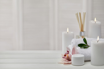 Foto auf Acrylglas Massagesalon Spa-Produkte mit aromatischen Kerzen, Orchideenblüte und Handtuch auf weißem Holztisch. Beauty Spa-Behandlung und Entspannungskonzept. Platz kopieren  © Rychko Yevhen
