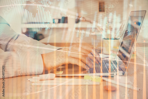 Double exposure of stock market graph with man working on laptop on background. Concept of financial analysis.