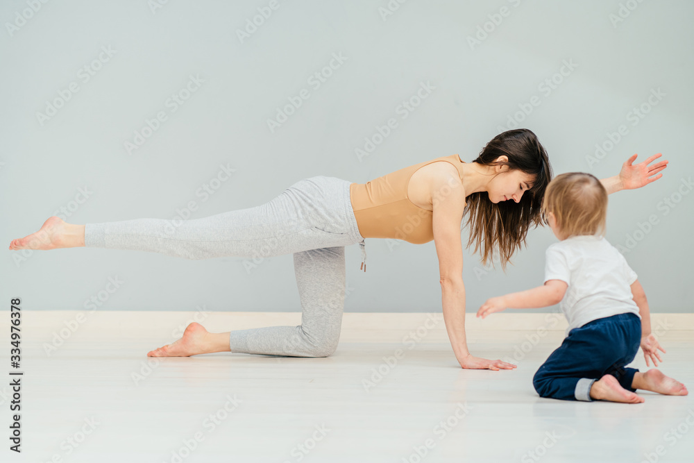 young mother does physical fitness exercises together with her baby young mother does physical fitness exercises together with her baby