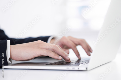 ノートパソコンでタイピングする日本人男性ビジネスマン