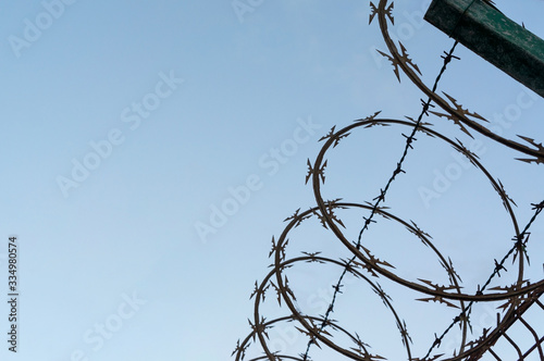 Barbed wire silhouette on a blue cloudy background