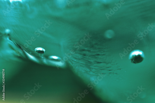 Macro Oxygen bubbles in water on a blue green background, concept such as ecology and other your successful projects