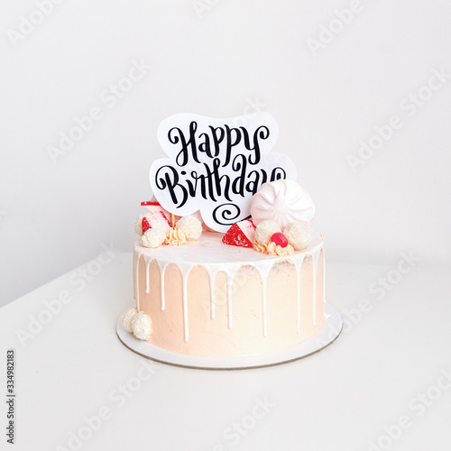 Beautiful pink birthday cake for a girl decorated with sweet candies with white background