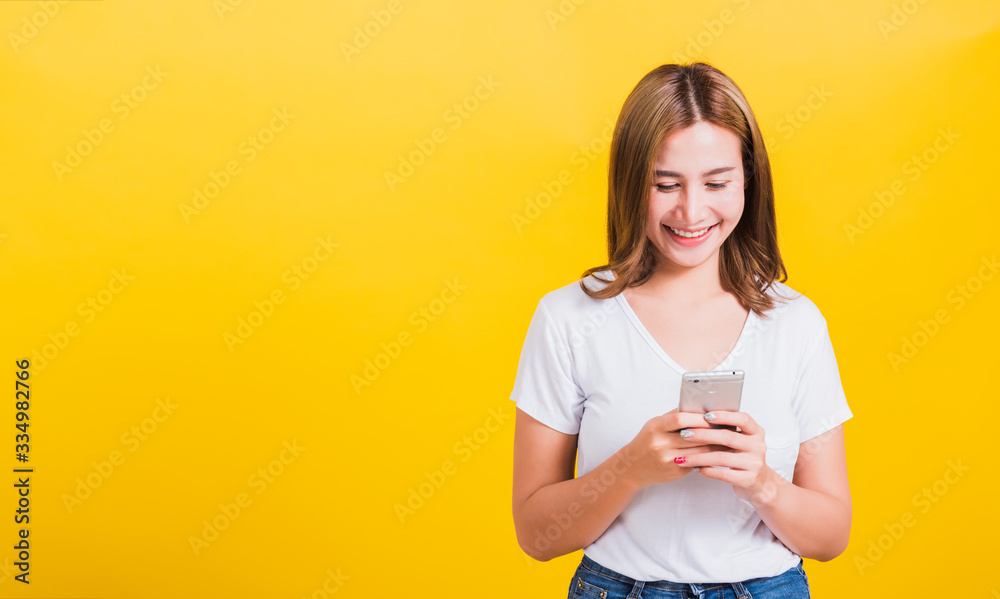 woman teen smile standing playing game or writing message on smartphone woman teen smile standing playing game or writing message on smartphone