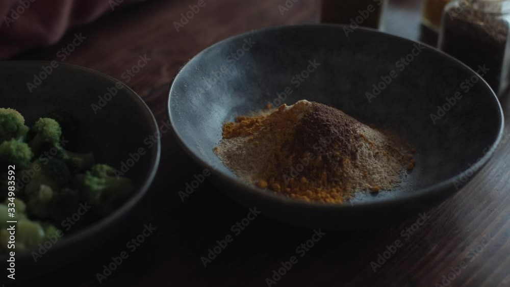 On the kitchen table are bowls with a mixture of spices and broccoli for preparing healthy foods. Close-up On the kitchen table are bowls with a mixture of spices and broccoli for preparing healthy foods. Close-up