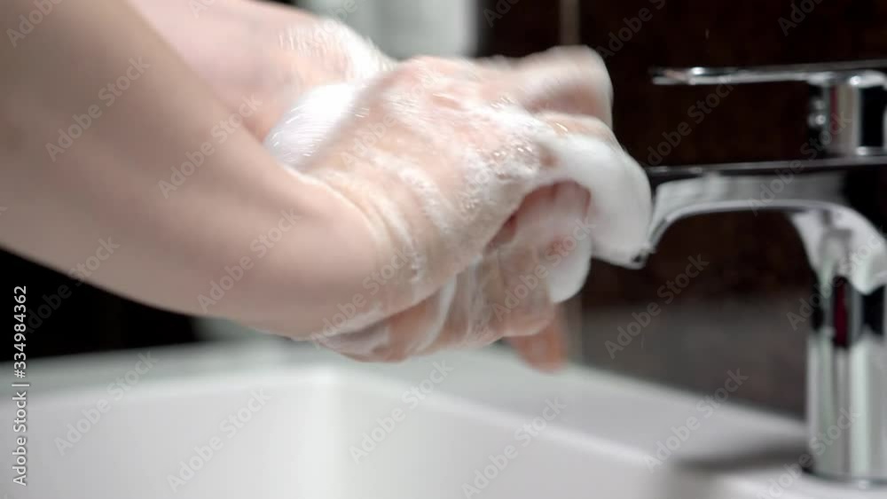 A young girl washes her hands thoroughly with soap. A young girl washes her hands thoroughly with soap.