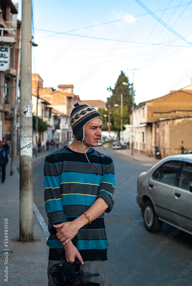 White Young Man Wears a Earflap Peruvian Hat (Chullo) and Holds a Camera