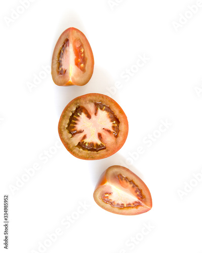 Sliced tomatoes halves and quarters on a white background. Place for text.