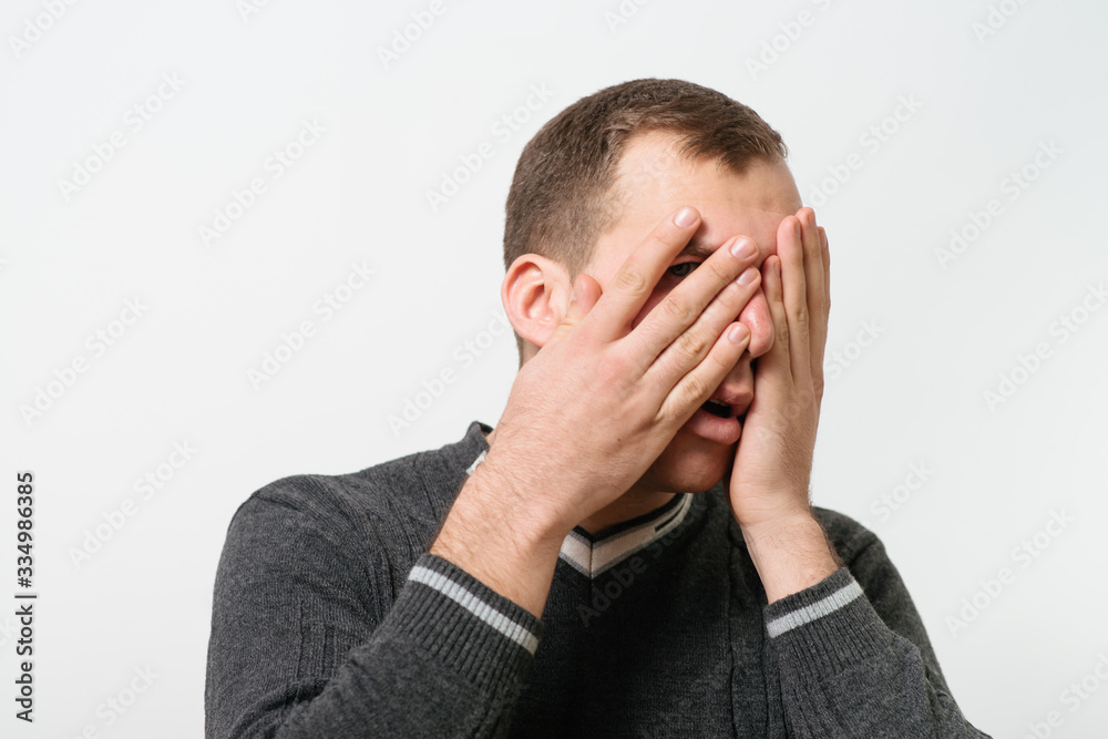 man covers his face by hand man covers his face by hand