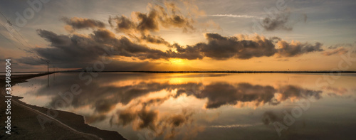Reflejos de las nubes en el agua al atardecer en el parque natural del delta del Ebro (Cataluña, España)