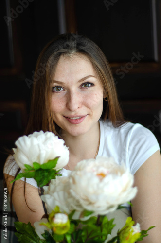 photo of a young beautiful girl in a room with flowers