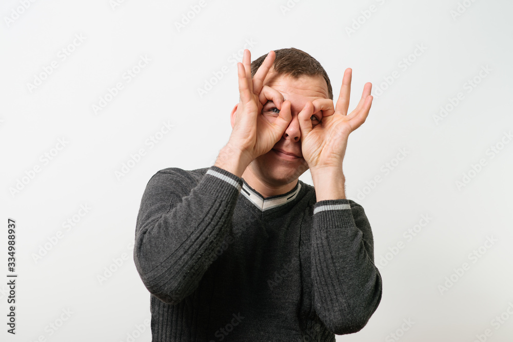 man looking through hands, making binoculars man looking through hands, making binoculars