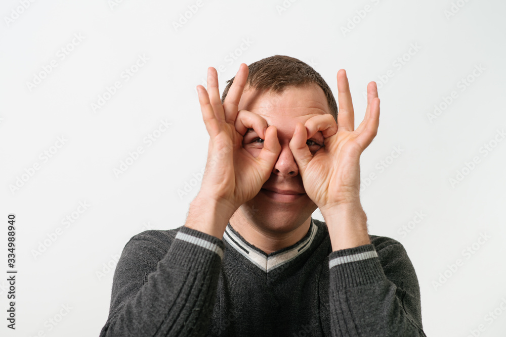 man looking through hands, making binoculars man looking through hands, making binoculars