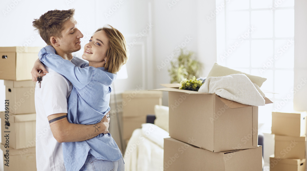 Happy smiling young couple showing a pair of keys of their new house