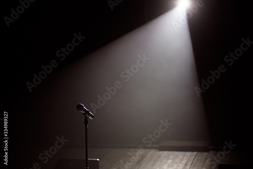 Close up of microphone on stage in black background.