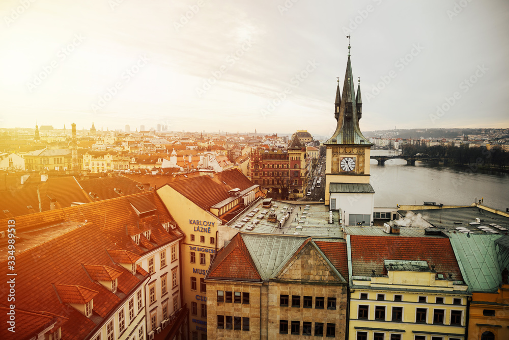 Obraz premium Vltava river and clock tower over looking the city taken during sunset hours in Prague, Czech republic. Old Town Water Tower, or Staromestska vodarna with tower clock on Vltava bank.