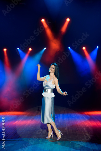 Artist posing on the scene in club. Bright stage lighting