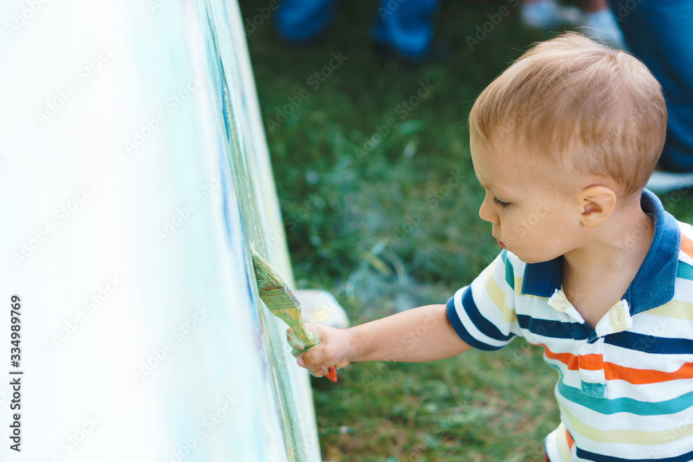 boy holding brush painting at park boy holding brush painting at park