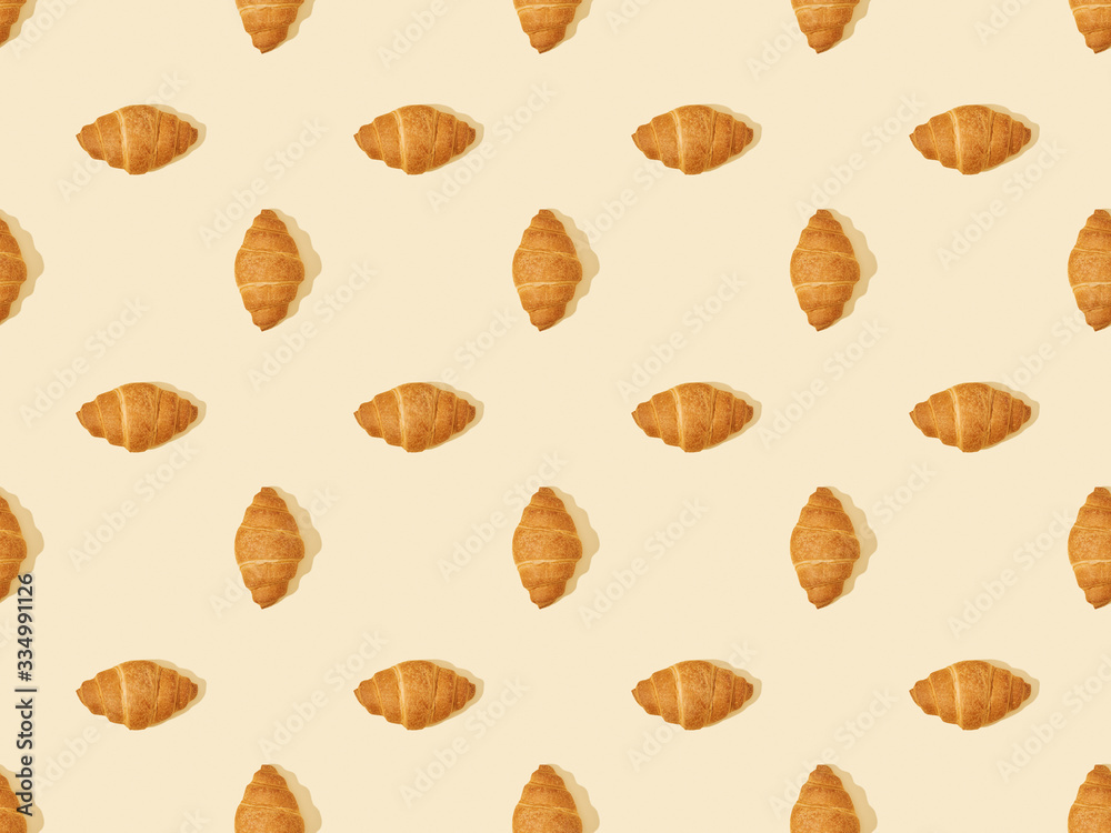top view of delicious fresh croissants on beige, seamless background pattern top view of delicious fresh croissants on beige, seamless background pattern
