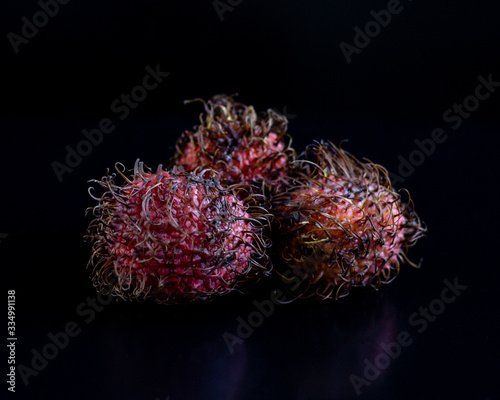 Rambutan on black background. Exotic fruit. HLS. Selective focus. Сloseup. photo