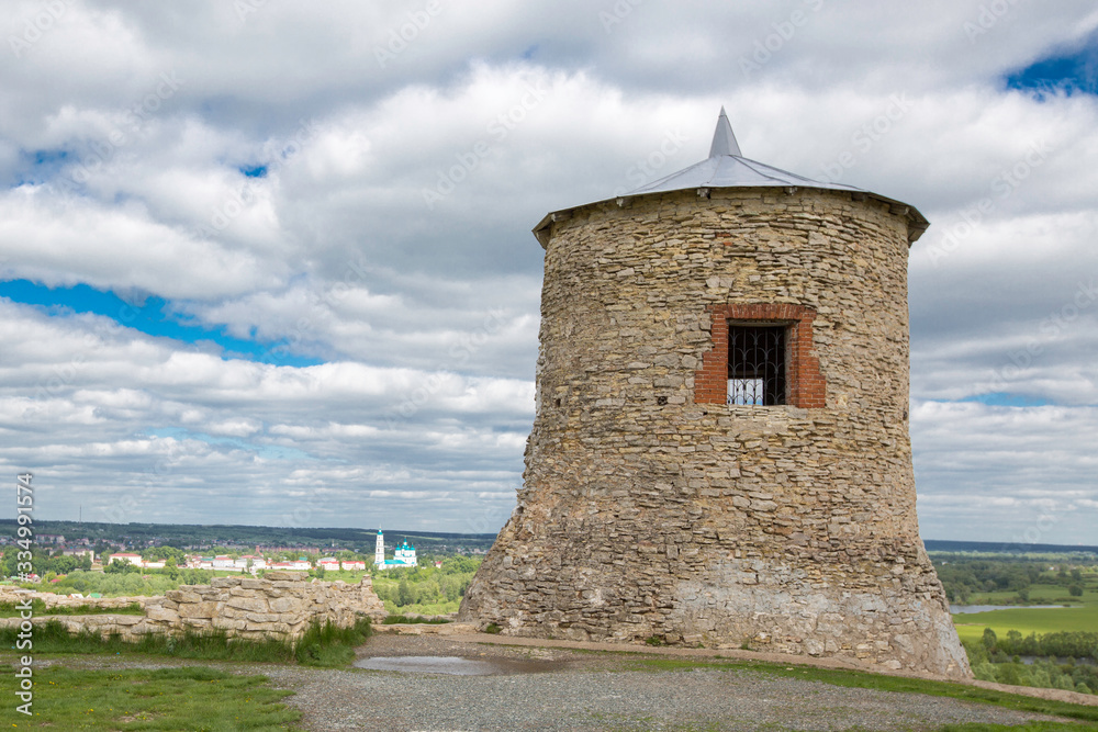 old stone fortress tower against a cloudy sky