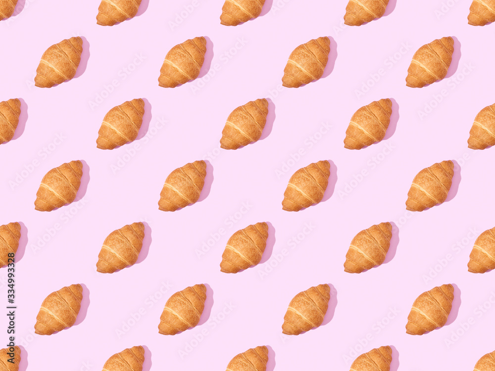 top view of croissants on pink, seamless background pattern top view of croissants on pink, seamless background pattern