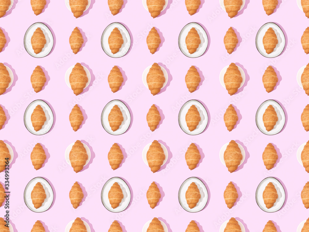 top view of croissants on plates on pink, seamless background pattern top view of croissants on plates on pink, seamless background pattern