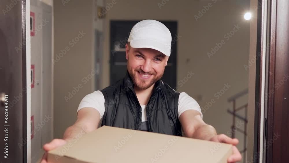 The delivery man smiles and hands the pizza box in his hands The delivery man smiles and hands the pizza box in his hands