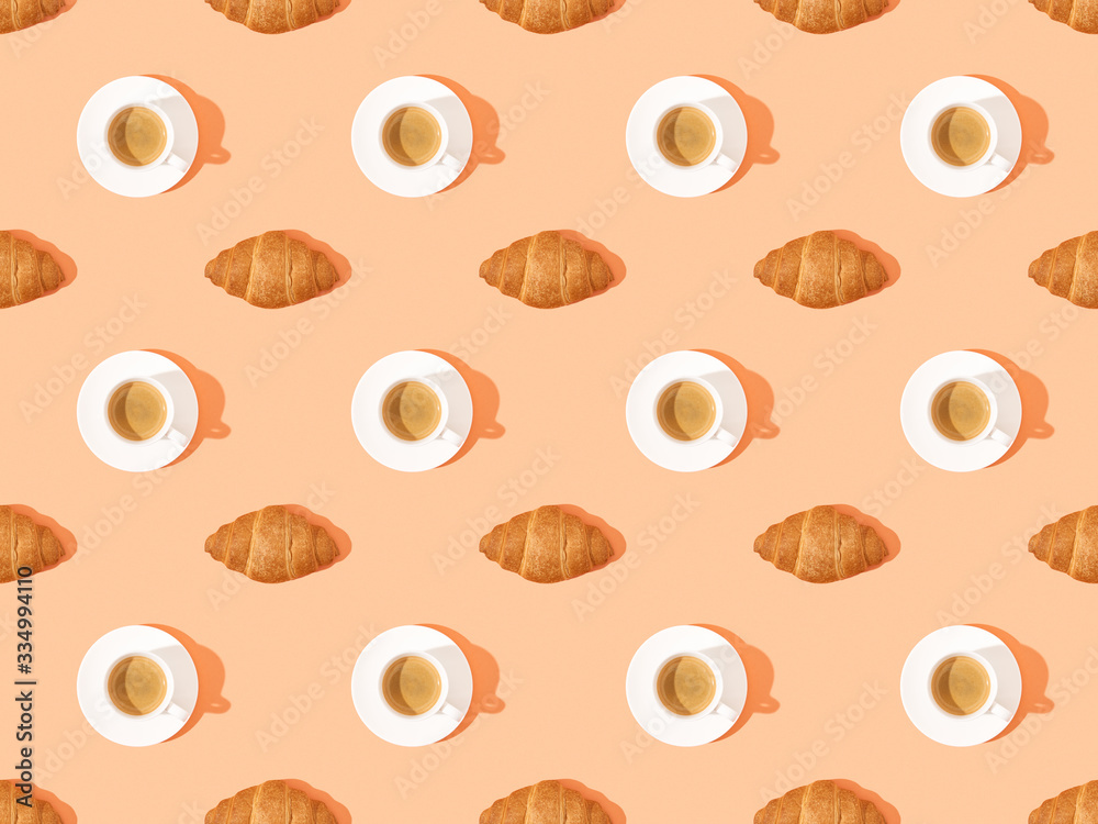 Obraz premium top view of fresh croissants on plates and coffee on orange, seamless background pattern