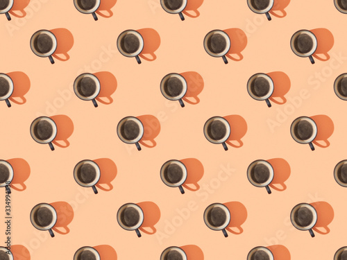 top view of cups of fresh coffee on orange, seamless background pattern