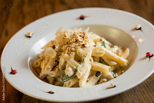 Penne with chicken, spinach and hazelnut in parmesan sauce