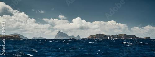 The Landscape of the balearic sea and improbable mountains, azure water, the storm sky, lonely boat on the horizon photo