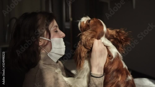 Smiling beautiful young girl hugging with her spaniel during quarantine at home. Coronavirus.COVID-19 photo