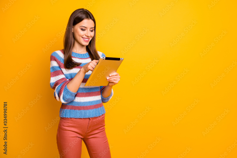Portrait of positive cheerful girl use tablet search interesting social media news wear good look jumper isolated over vibrant color background Portrait of positive cheerful girl use tablet search interesting social media news wear good look jumper isolated over vibrant color background