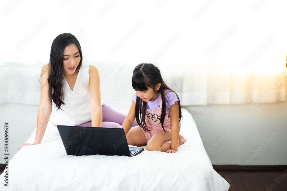 Mother And Teenage Daughter Looking At Laptop Together. Work from home and social distancing concept Mother And Teenage Daughter Looking At Laptop Together. Work from home and social distancing concept