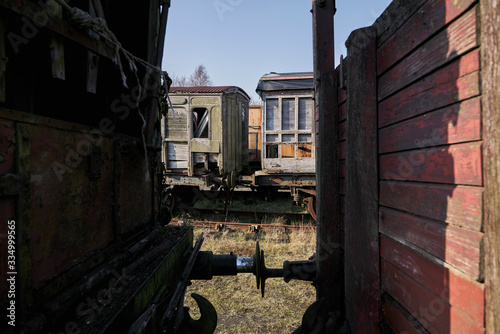 Abandoned train depot with various trains and carriages in different states of decay.